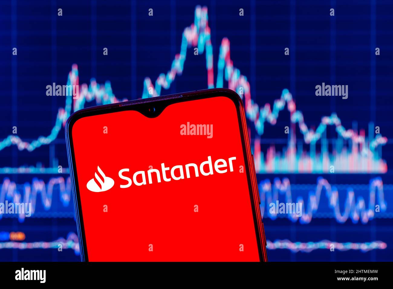 Smartphone with Santander bank logo. Santander stock chart on background. Stock Photo