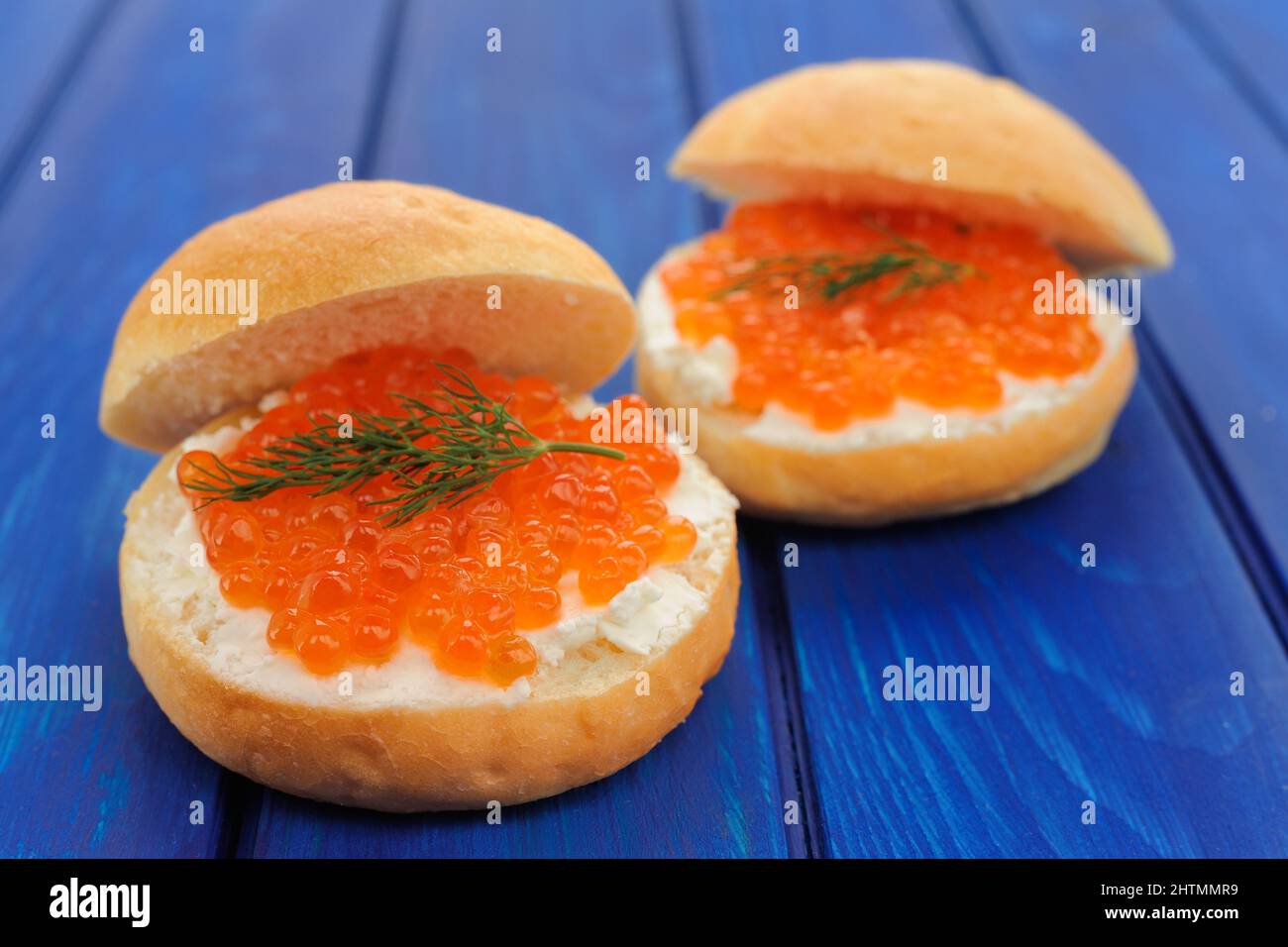Delicious red caviar and green dill burgers on buns with cream cheese