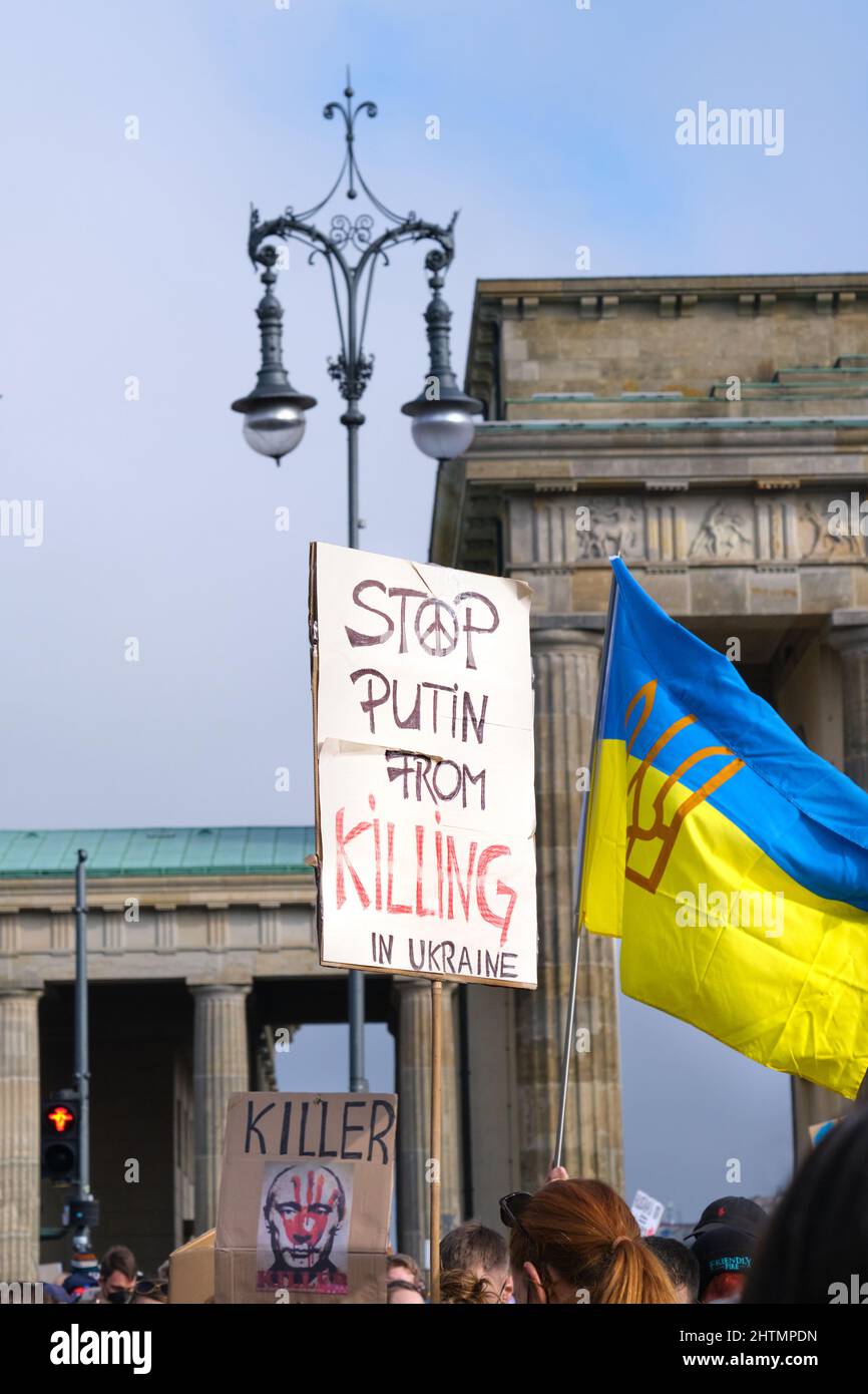 Packard with text Stop Putin from killing in Ukraine. Yellow blue Ukrainian flag. Protest against war in Ukraine by Brandenburg Gate in Berlin. Stock Photo