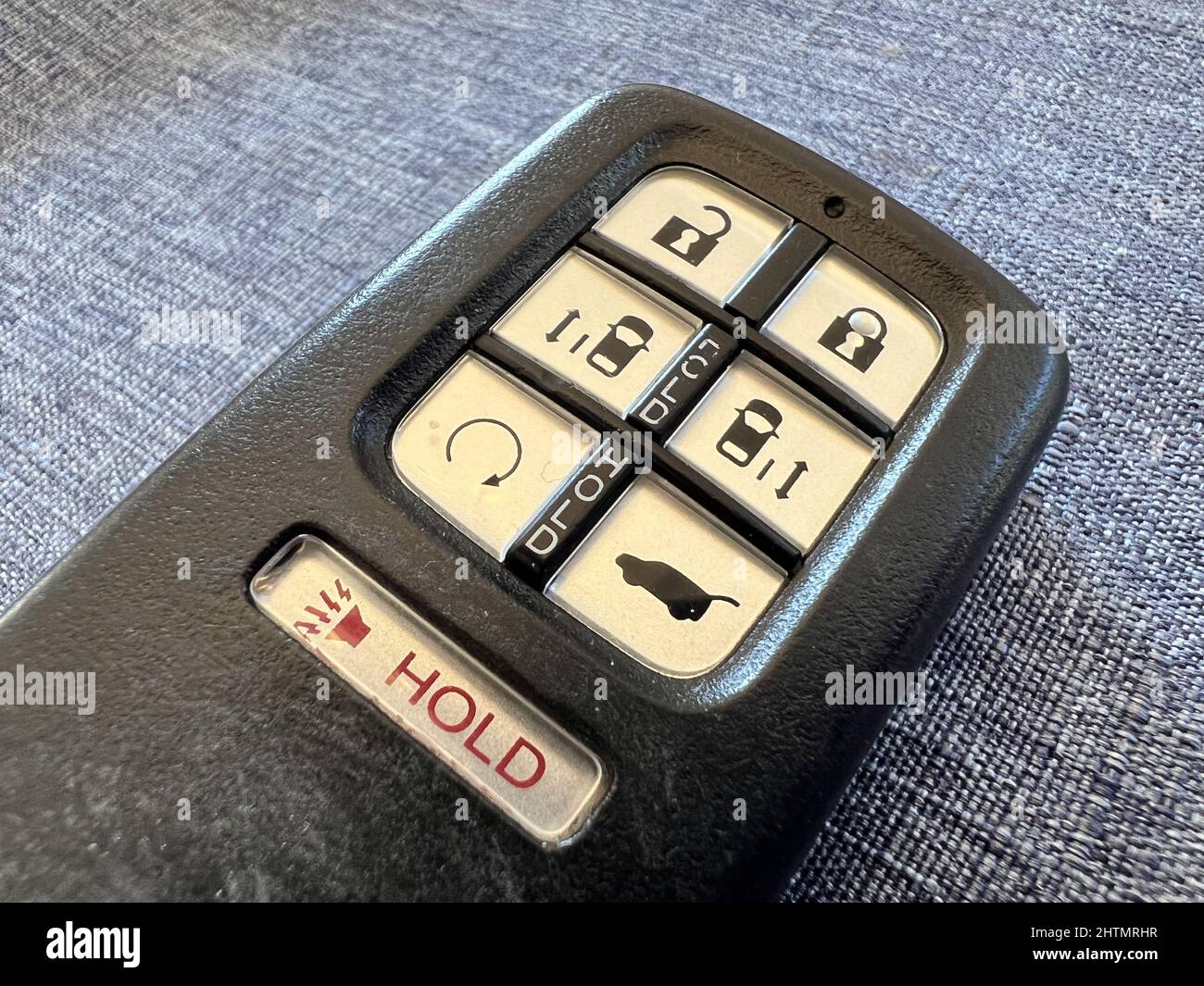 Automotive keyfob with buttons for remote engine start, door locking and unlocking, and car alarm panic button on light gray surface, Lafayette, California, January 20, 2022. Photo courtesy Tech Trends. Stock Photo