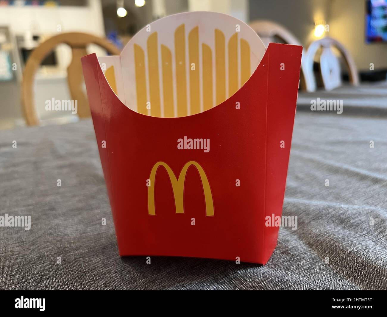 An empty McDonald's french fry container is visible on a table in a