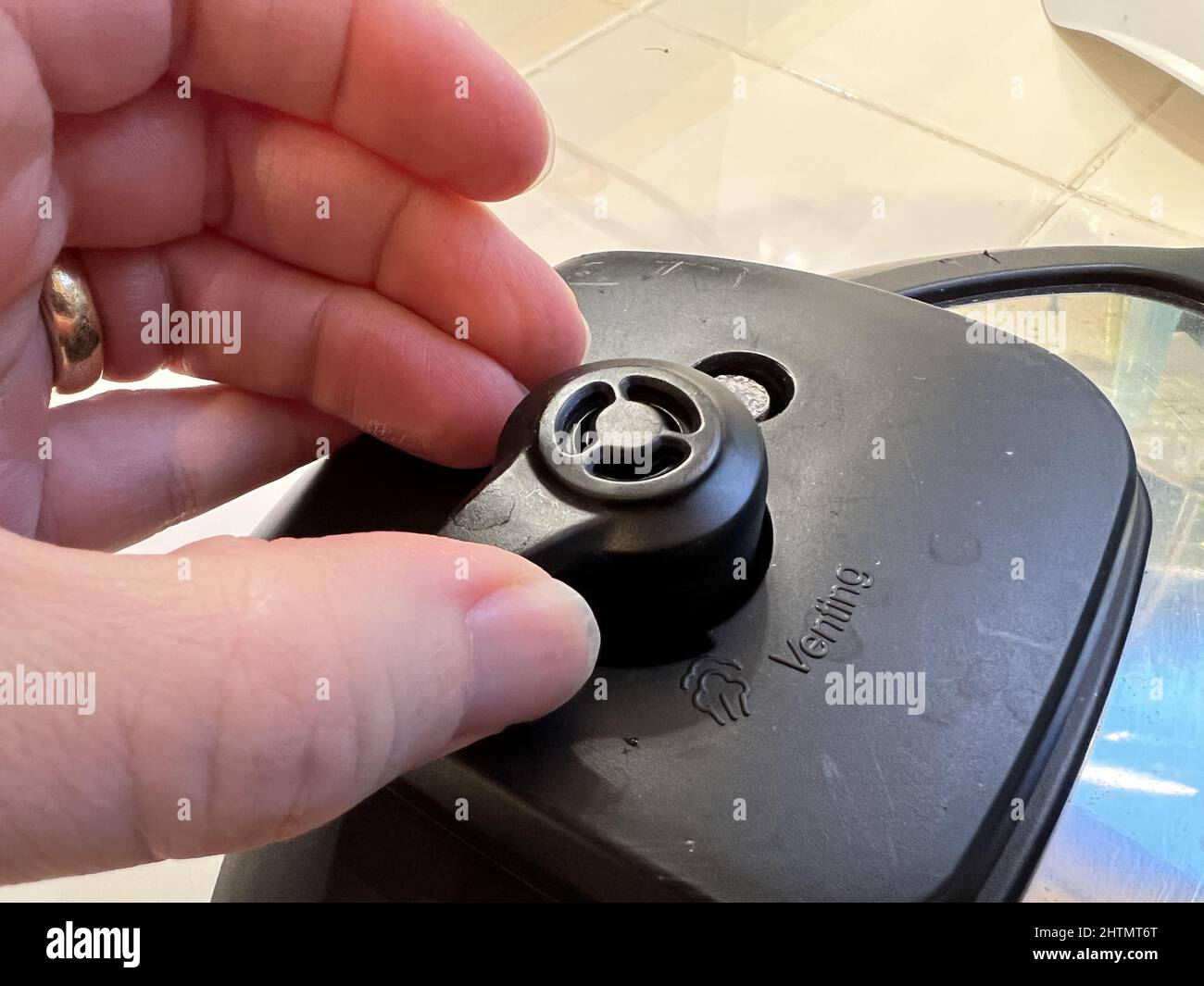A person's hand adjusts the pressure valve on an Instant Pot pressure cooker,  Lafayette, California, February 8, 2022. Photo courtesy Sftm Stock Photo -  Alamy