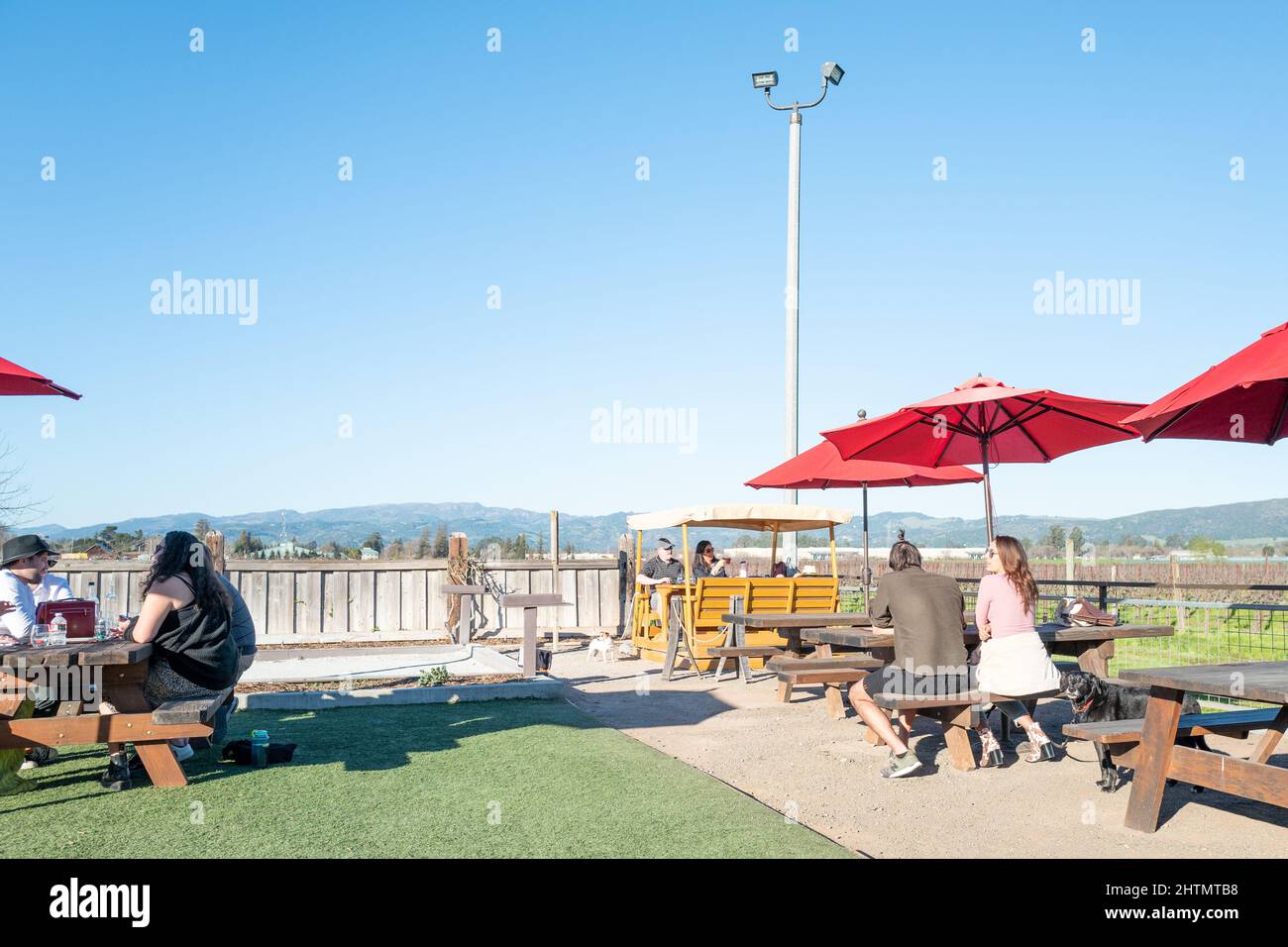 Outdoor tasting area with picnic tables and visitors at Larson Family