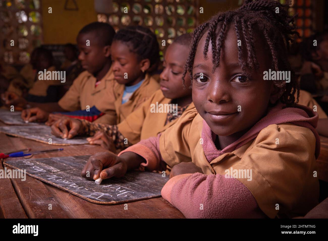 Students in a school in Africa take the lesson and write notes on a