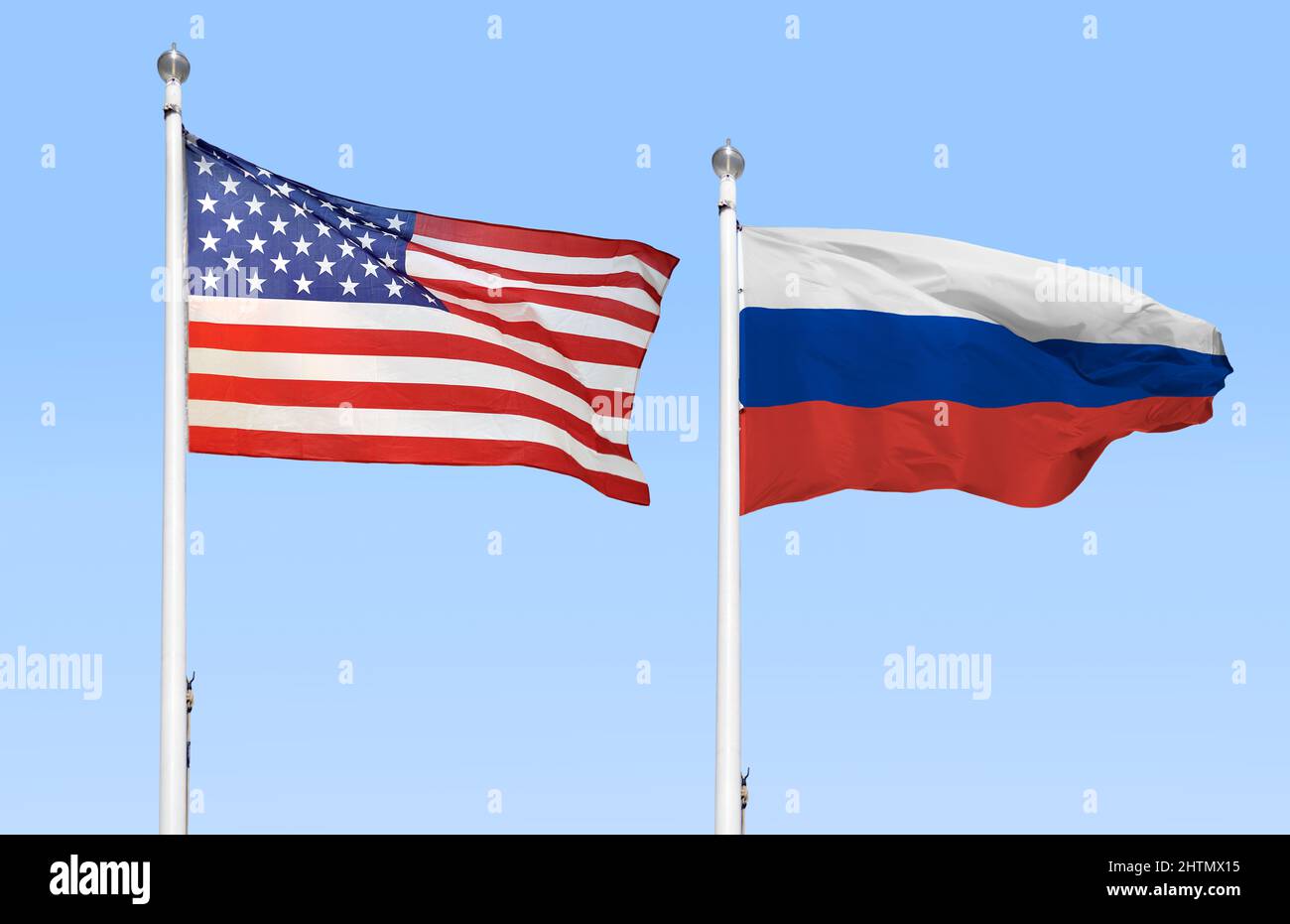 The American and Russian flags flying side by side with blue sky Stock Photo