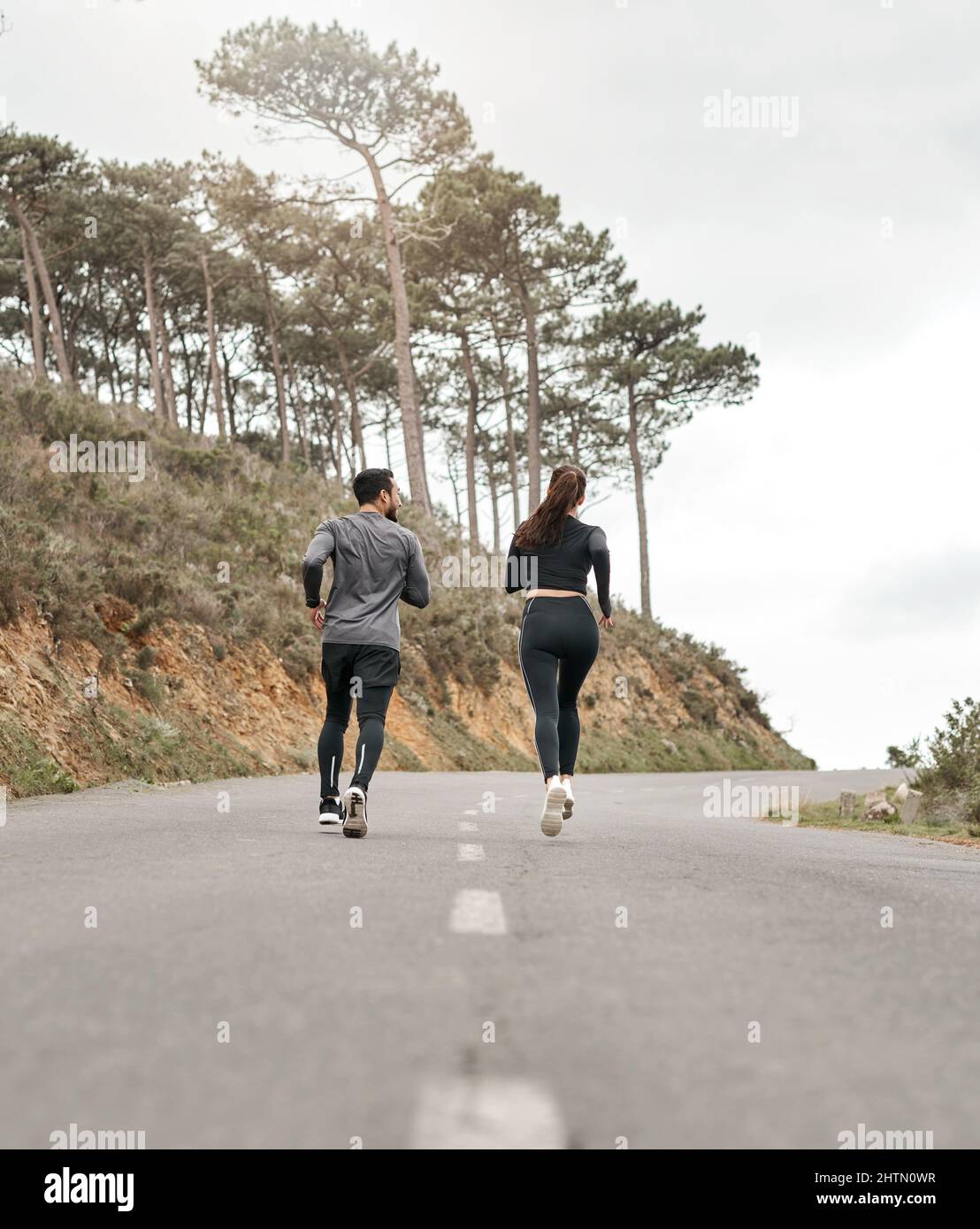 Fitness doesnt take off days. Full length shot of two unrecognizable athletes bonding together during a run outdoors. Stock Photo