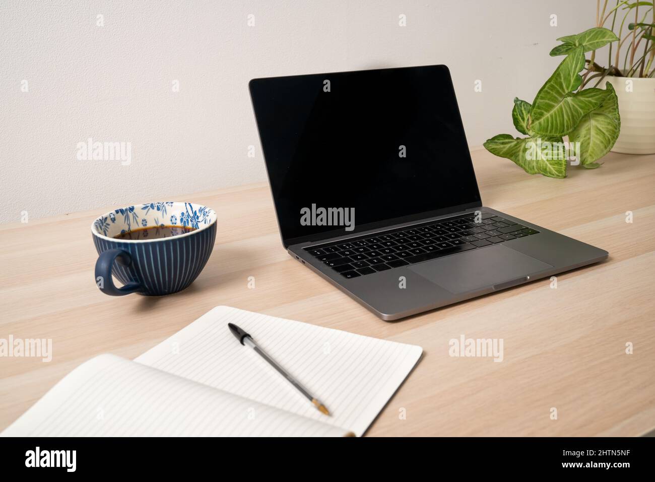 Laptop, notepad and coffee on desk Stock Photo