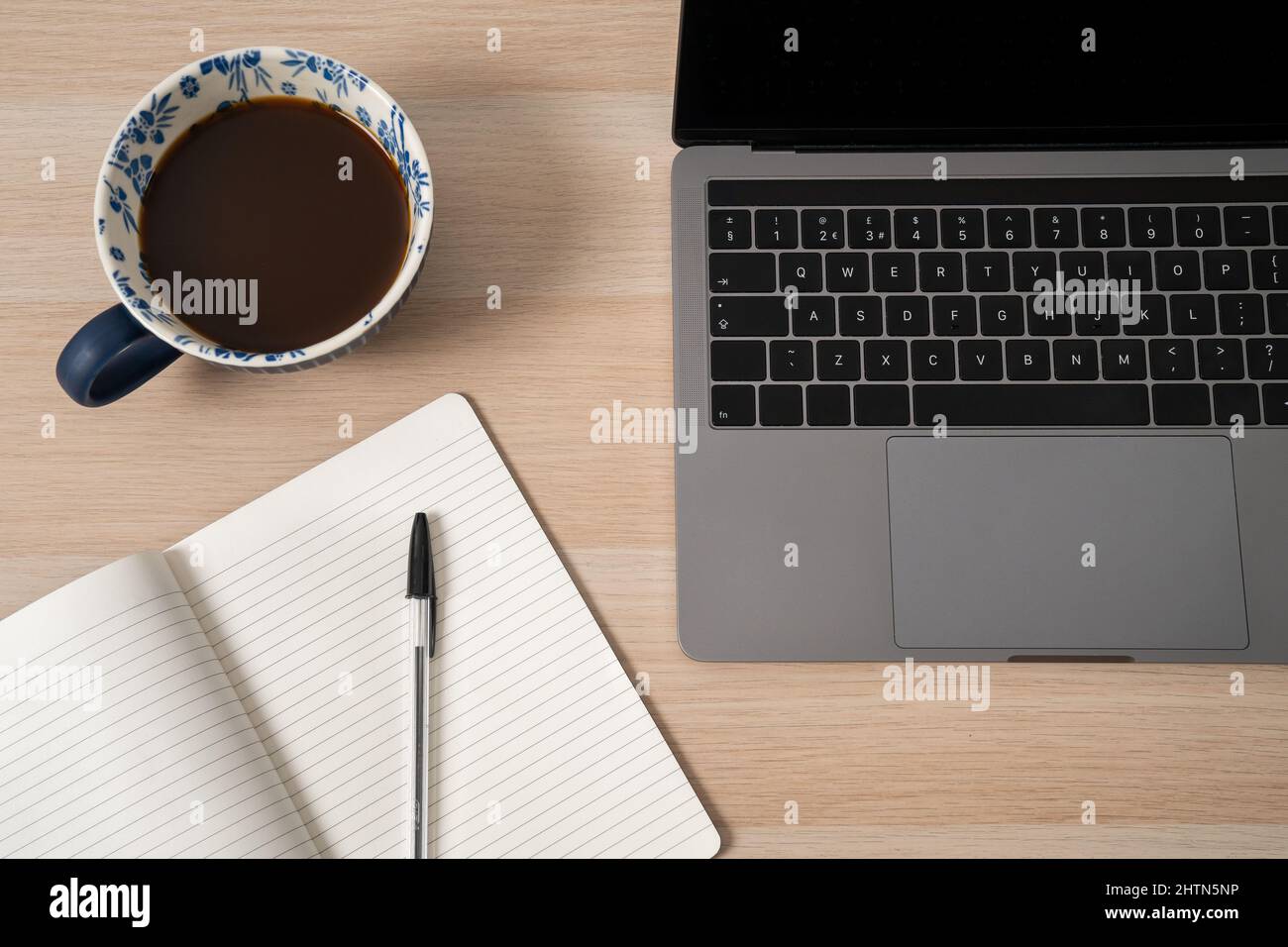 Laptop, notepad and coffee on desk Stock Photo
