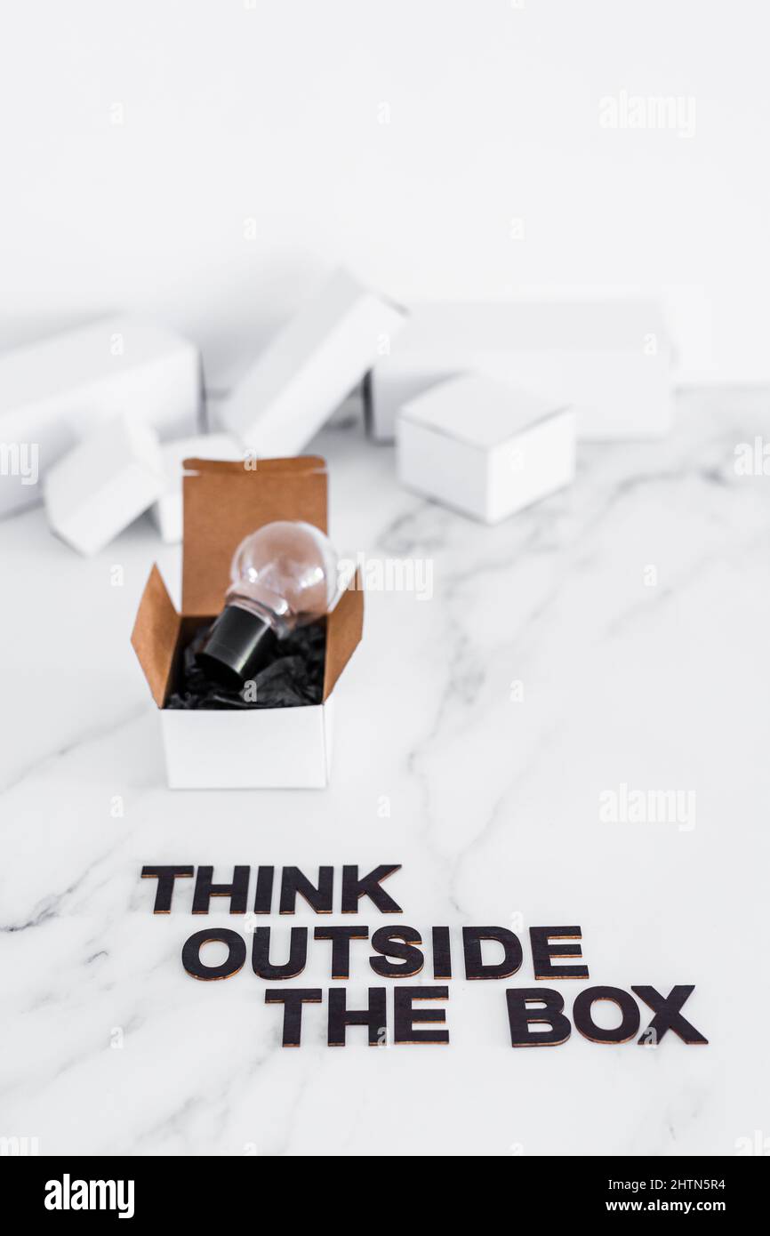 Think outside the box concept with idea lightbulb on top of white box ...