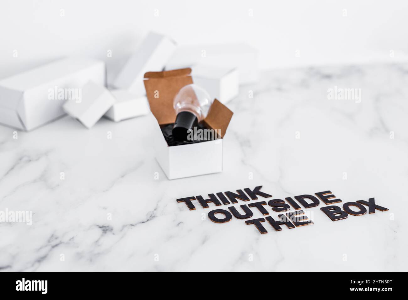 Think outside the box concept with idea lightbulb on top of white box ...