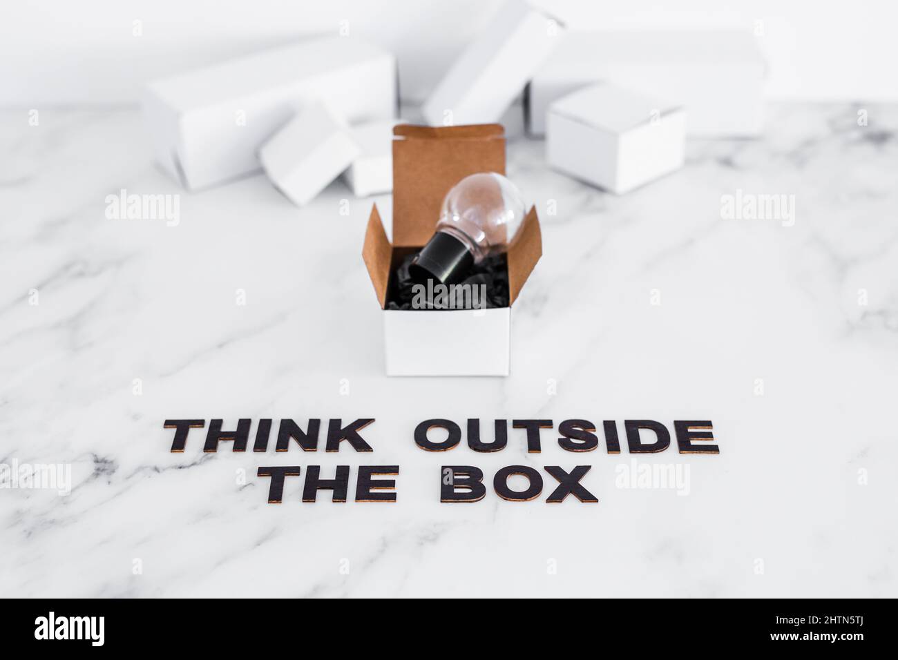 Think outside the box concept with idea lightbulb on top of white box ...