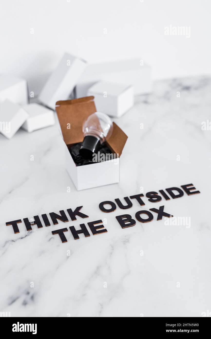 Think outside the box concept with idea lightbulb on top of white box ...
