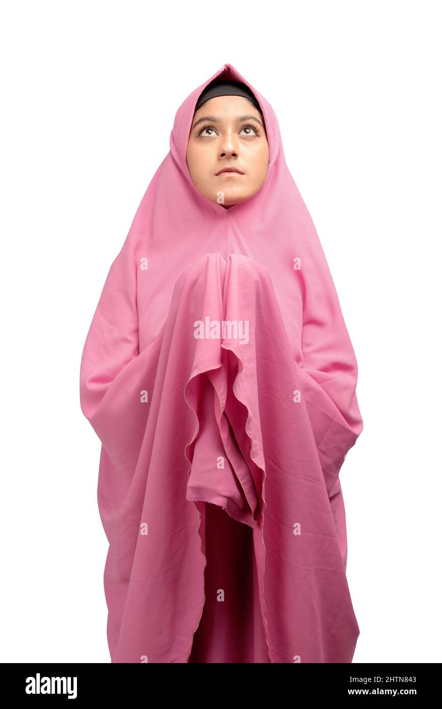 Asian Muslim woman in a veil standing while raised hands and praying ...