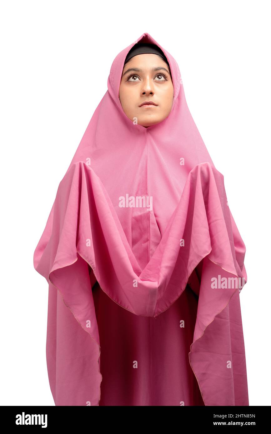 Asian Muslim woman in a veil standing while raised hands and praying ...