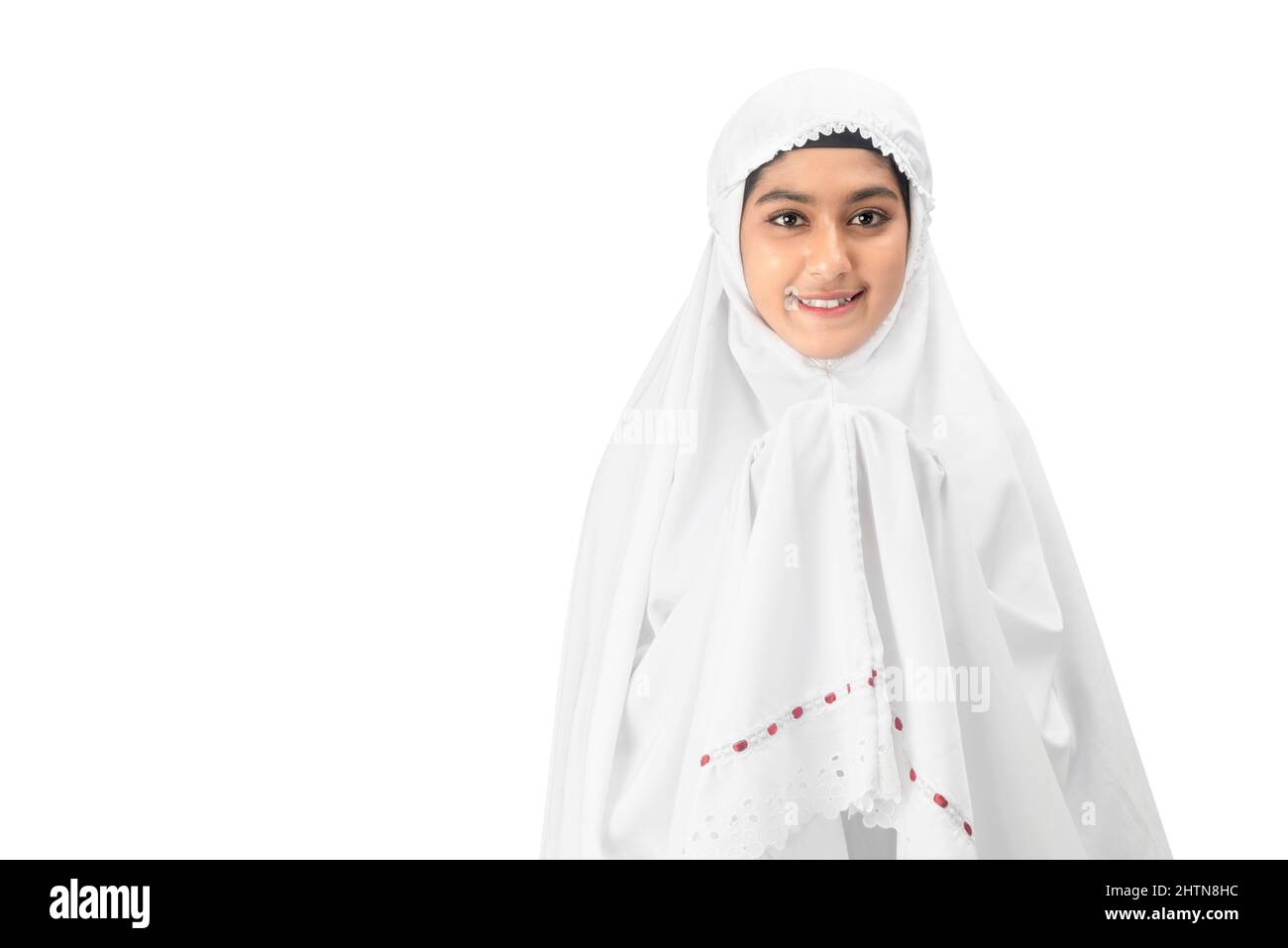 Asian Muslim woman in a veil standing while raised hands and praying ...