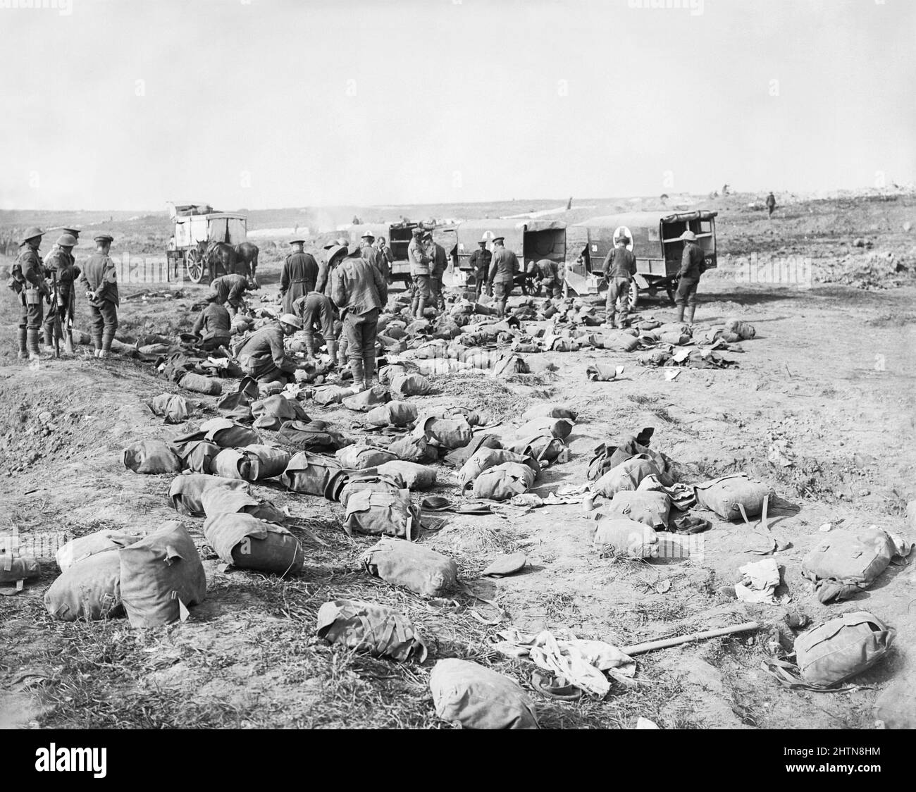The Battle of Guillemont. 3 -5 September 1916. Troops of RAMC (Royal Army Medical Corps) search the packs of the dead for letters and effects to be sent to relatives after the Battle of Guillemont (3-5 Sept 1916) during The Battle of the Somme. Horse and motor ambulances in the background. Stock Photo