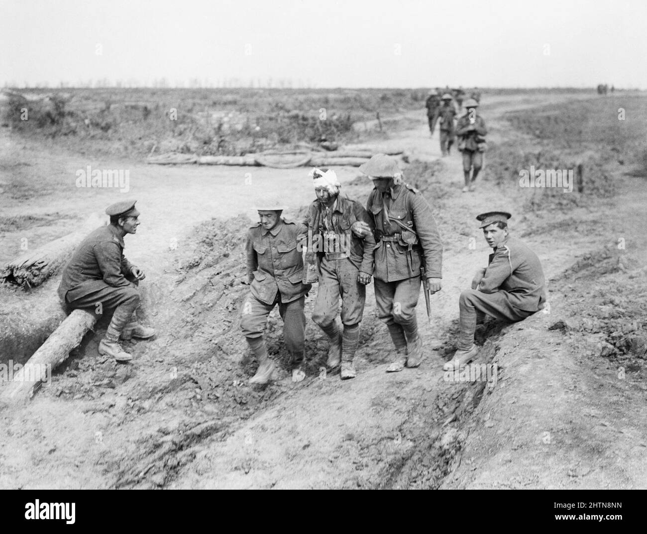 Bringing in the British wounded across open country after the capture of Guillemont. Chimpanzee Valley, near Montauban, 3rd September 1916. Two soldiers seated on the side of the path are probably the Royal Field Artillery servicemen. Stock Photo