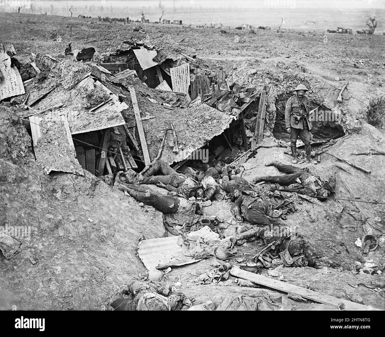 Dead German soldiers behind a destroyed machine-gun post. Horse drawn ambulances of the Royal Army Medical Corps (RAMC) in background. Near Guillemont. September 1916. Stock Photo