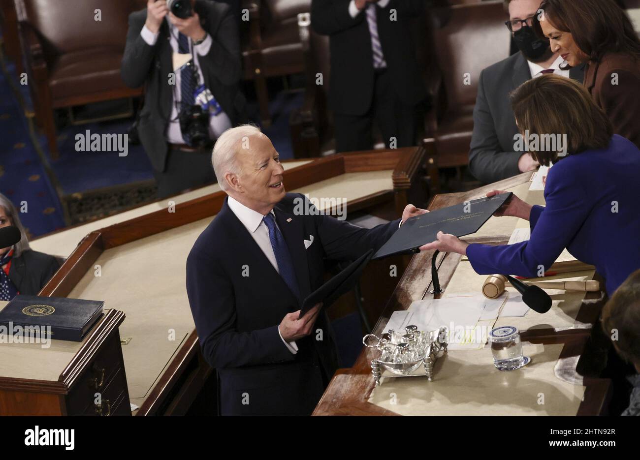 Washington, United States. 01st Mar, 2022. U.S. President Joe Biden hands a copy of his speech to Speaker of the House Nancy Pelosi in front of Vice President Kamala Harris as he arrives to deliver his State of the Union address to a joint session of the U.S. Congress in the House of Representatives Chamber at the Capitol in Washington, U.S. March 1, 2022. Pool Photo by Evelyn Hockstein/UPI Credit: UPI/Alamy Live News Stock Photo