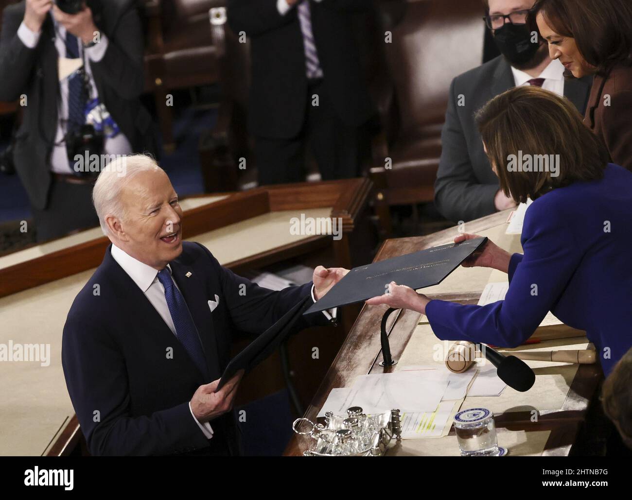 Washington, United States. 01st Mar, 2022. U.S. President Joe Biden hands a copy of his speech to Speaker of the House Nancy Pelosi in front of Vice President Kamala Harris as he arrives to deliver his State of the Union address to a joint session of the U.S. Congress in the House of Representatives Chamber at the Capitol in Washington, DC, March 1, 2022. Pool Photo by Evelyn Hockstein/UPI Credit: UPI/Alamy Live News Stock Photo