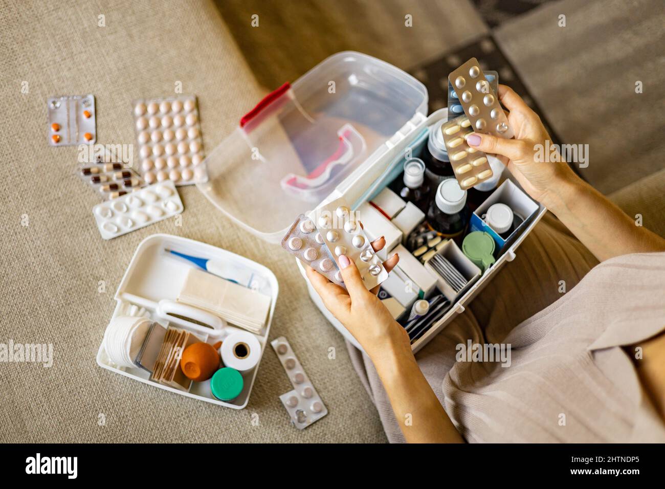 Closeup female hand placing medicament domestic first aid kit. Storage
