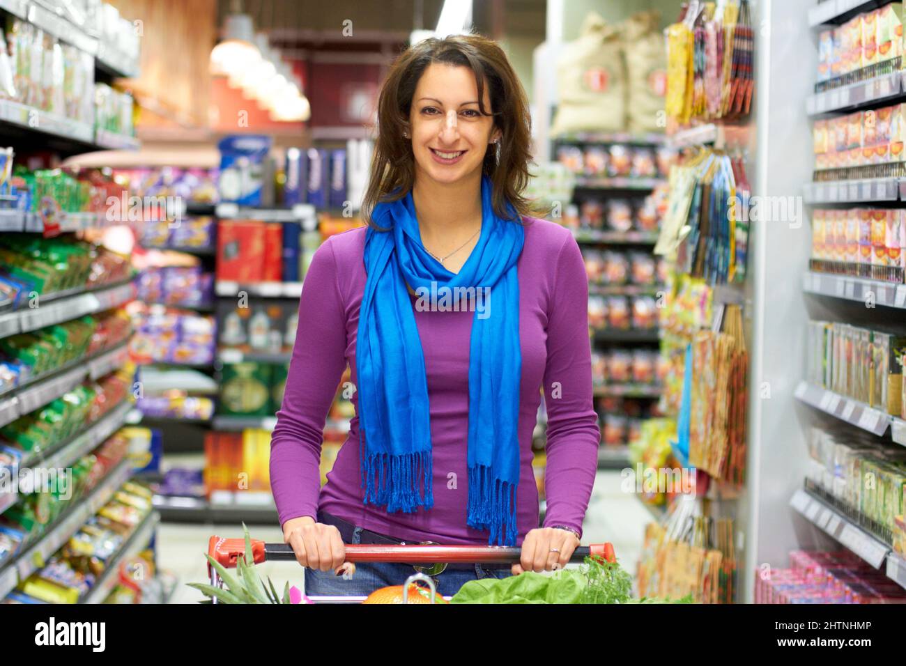 Luxury of many choices. A woman pushing her shopping cart in a grocery store. Stock Photo