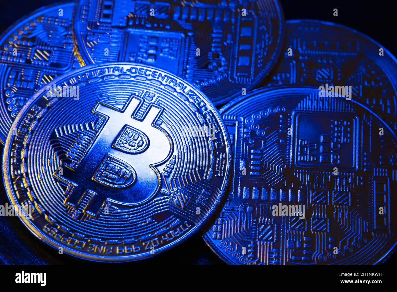 A handful of Bitcoin coins in a beautiful blue light on a dark background.  BTC cryptocurrency. Blockchain technology. Close-up Stock Photo - Alamy