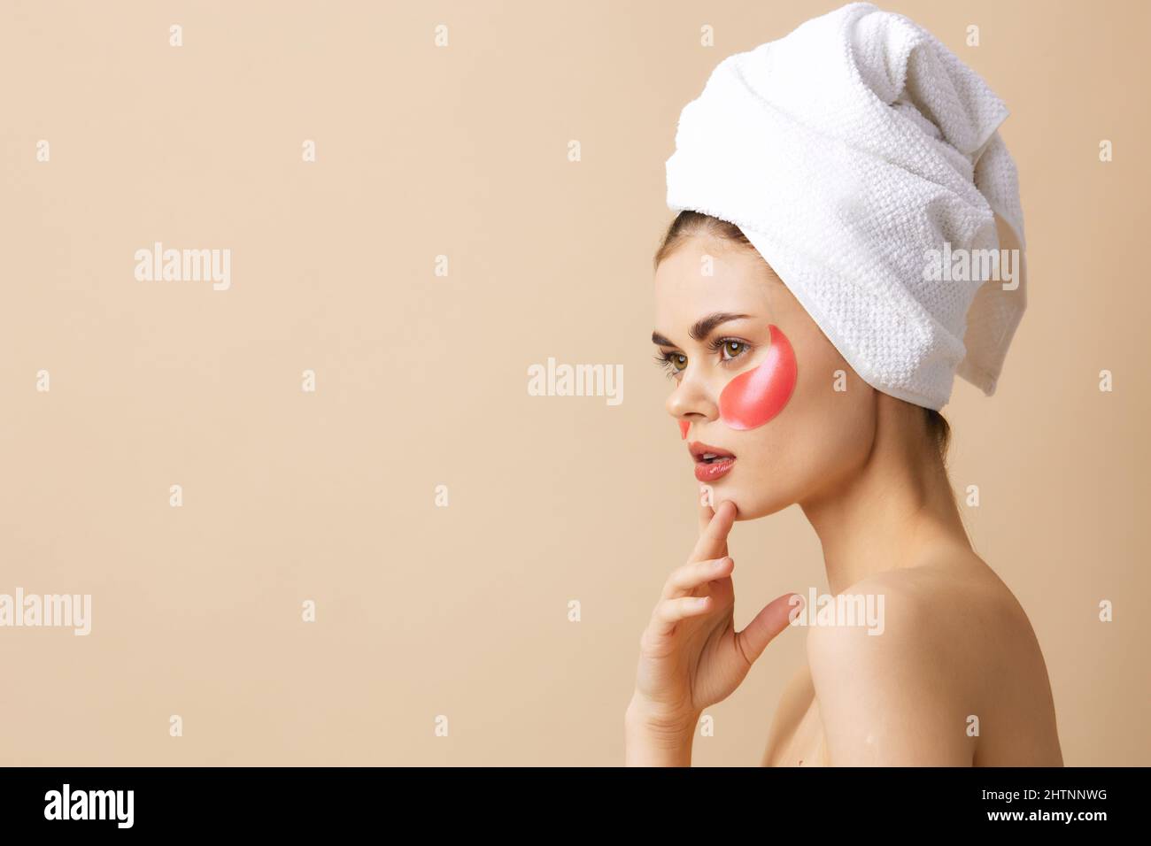 portrait-woman-pink-patches-on-the-face-with-a-towel-on-the-head-beige