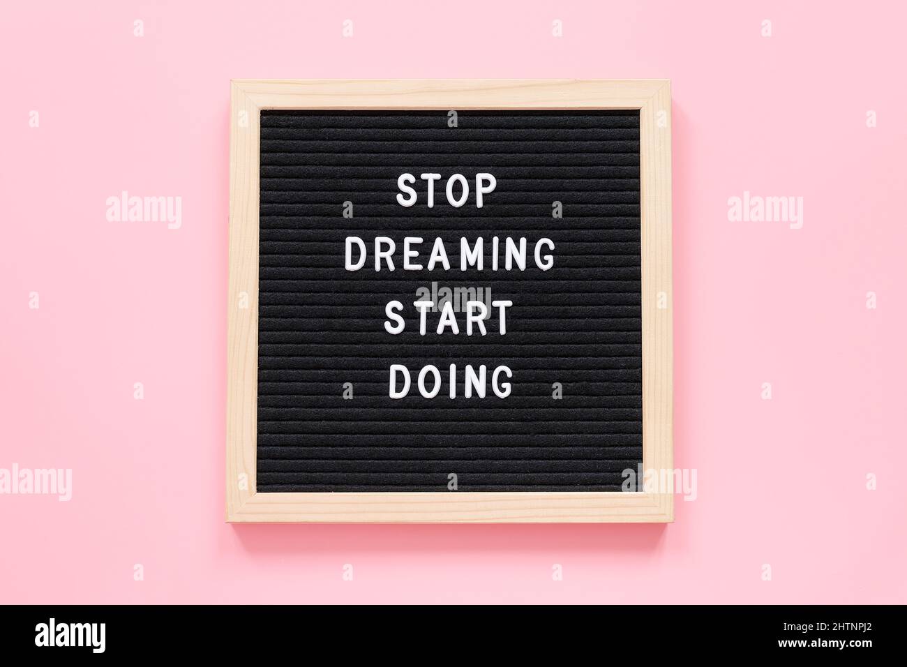 Stop Dreaming Start Doing. Motivational quote on letterboard on pink background. Top view Flat lay Concept inspirational quote of the day. Stock Photo