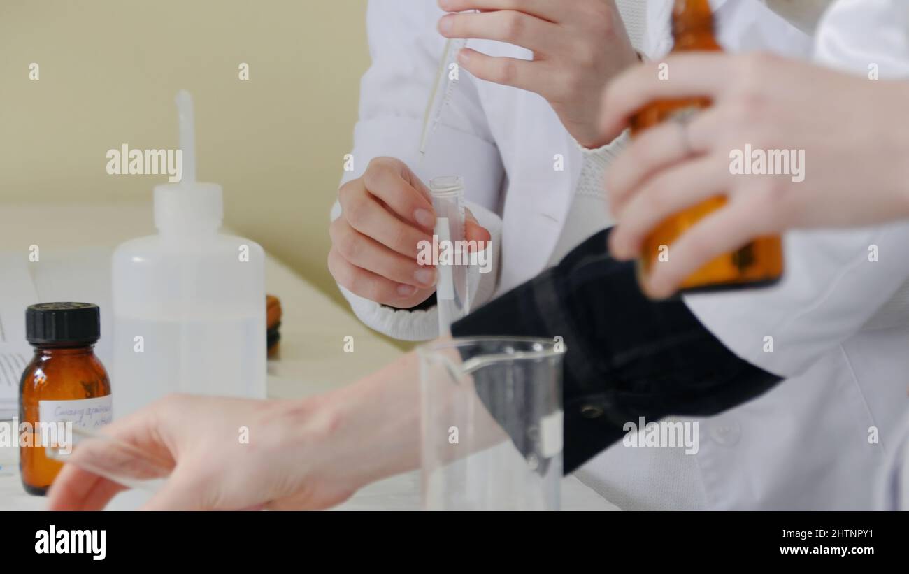 Medical worker with dropper testing fluids. Student used laboratory