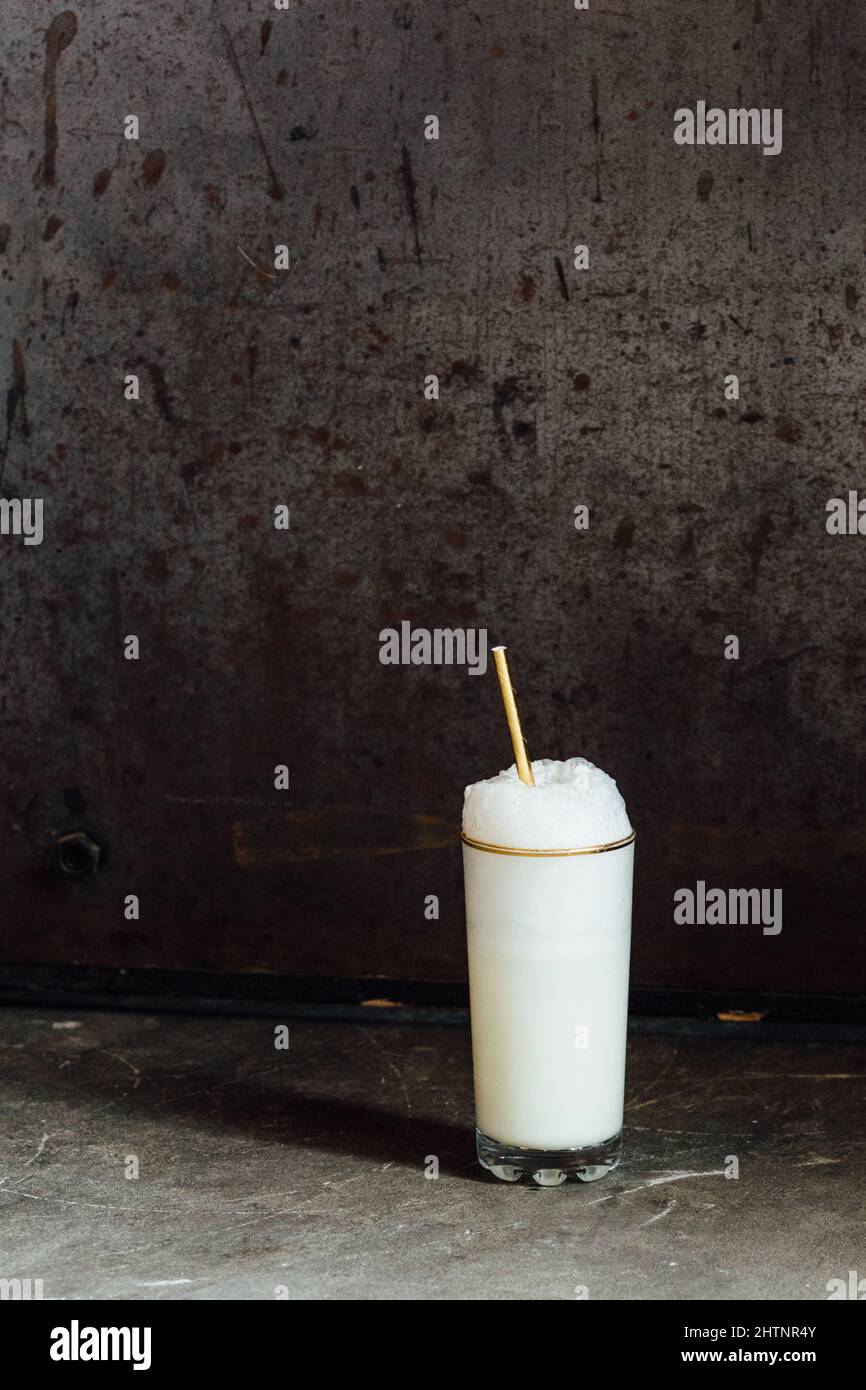 Ramos gin fizz milkshake white foam in goldrimmed tall glass with gold