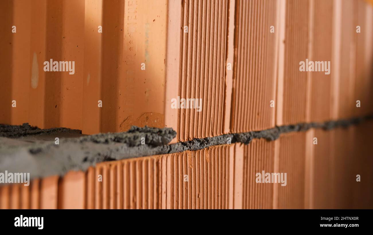 Bricklayer tapping down a block wall. Stock footage. Construction