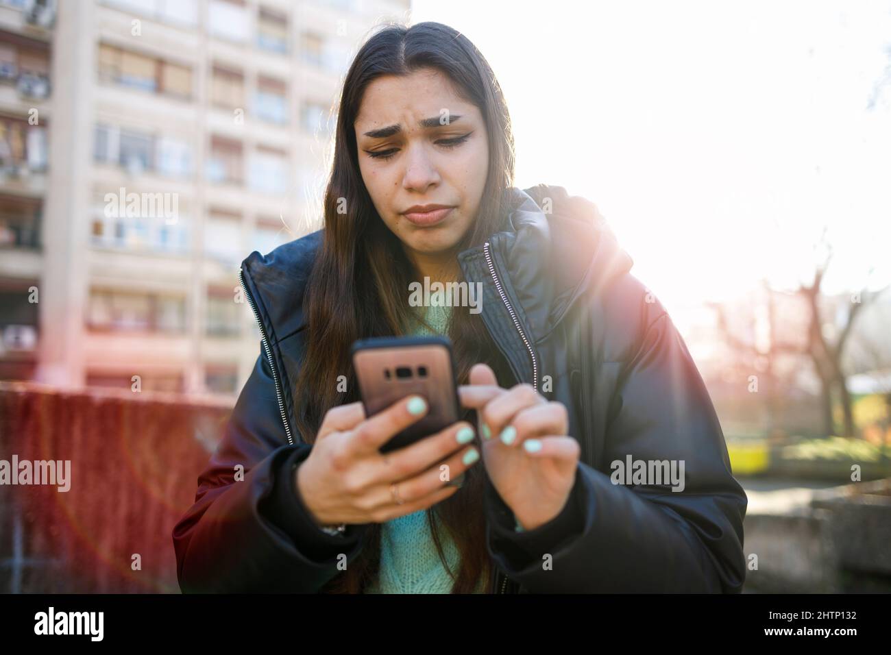Young woman expressing distress while she reads about the news about the war in Ukraine Stock Photo