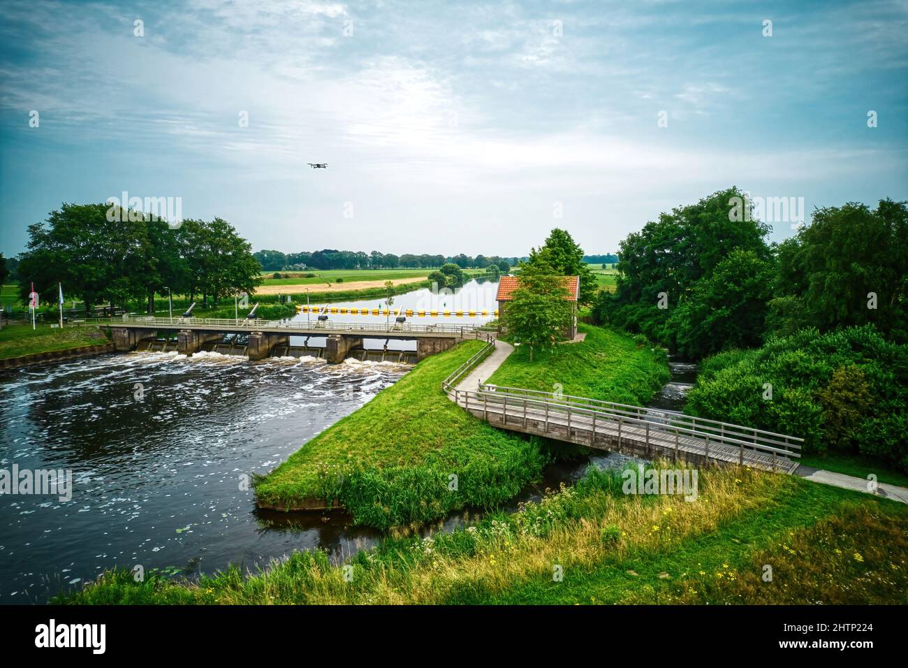 Drone view of the river the Vecht, beautiful blue sky and cycle path. Bridge and weir in the river. Flying drone in the sky. Dalfsen Netherlands Stock Photo