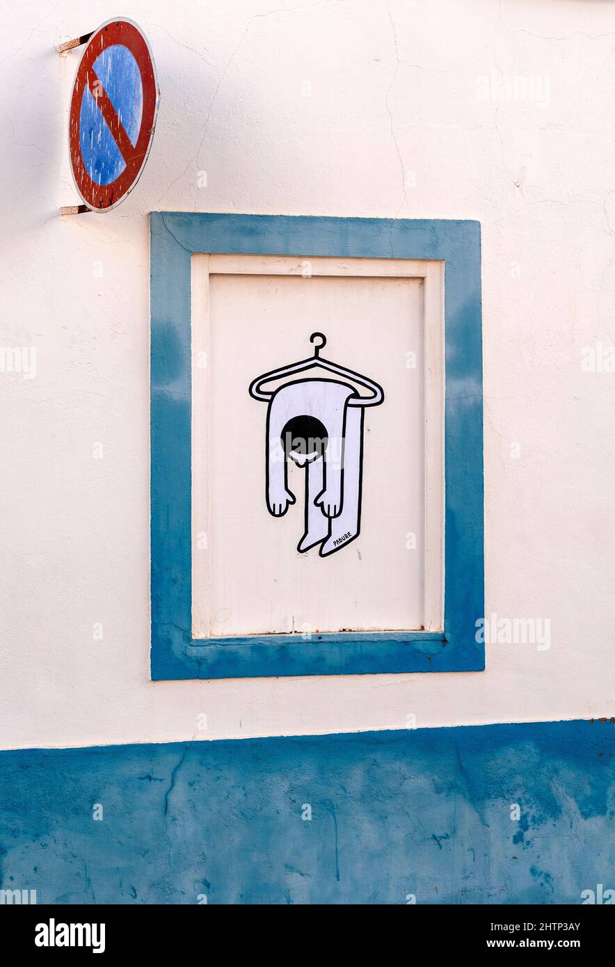 Quirky stencilled art added to a window frame -  figure of person over a coat-hanger Stock Photo