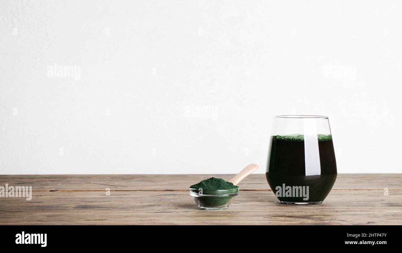 fresh green drink with spirulina in glass, spirulina powder with spoon