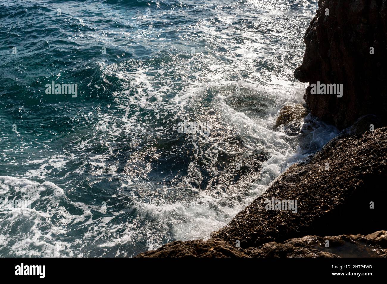 Waves splashing at rocks at the beach Stock Photo - Alamy