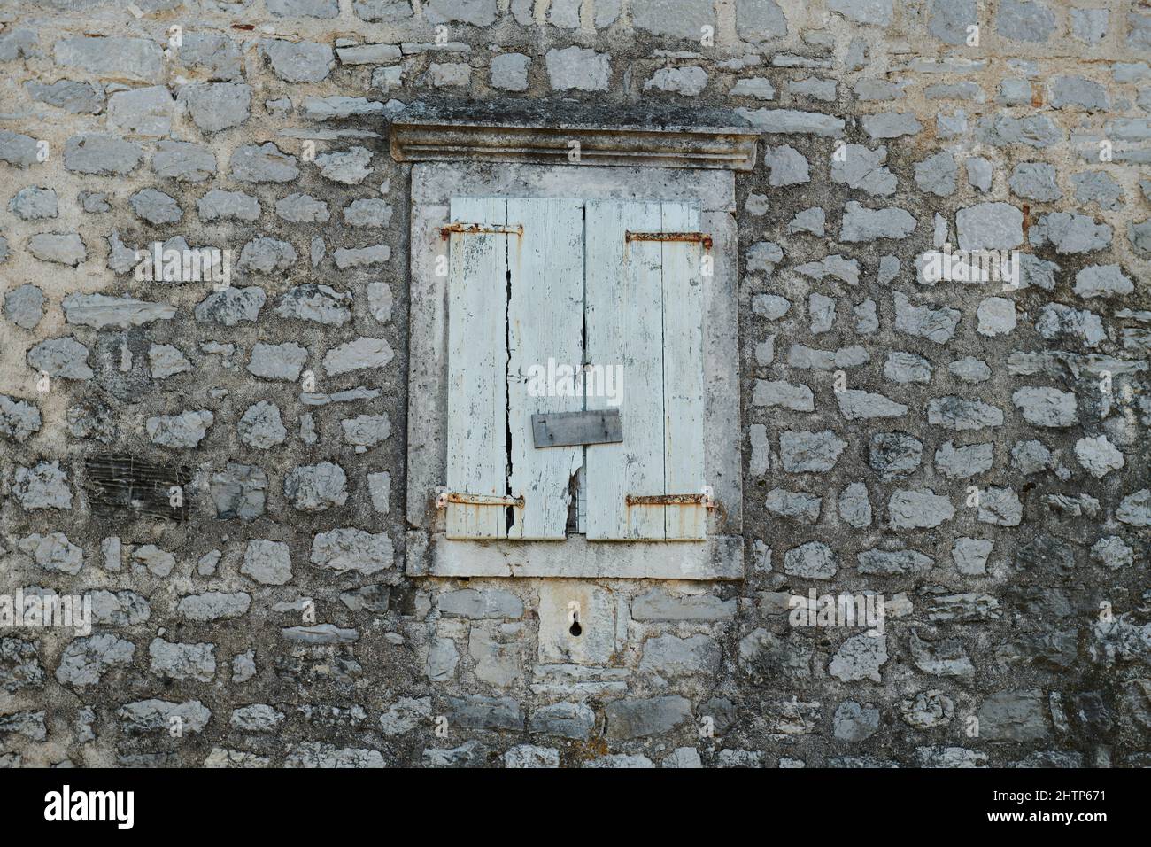 the stone wall is old and the window is shuttered Stock Photo - Alamy