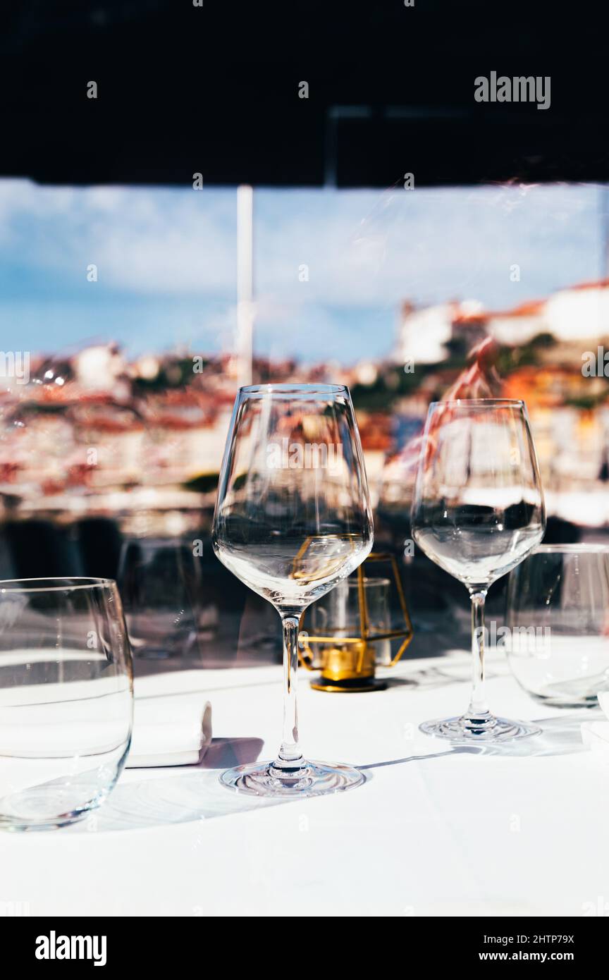 Empty glasses of wine on table in restaurant. Porto old town embankment