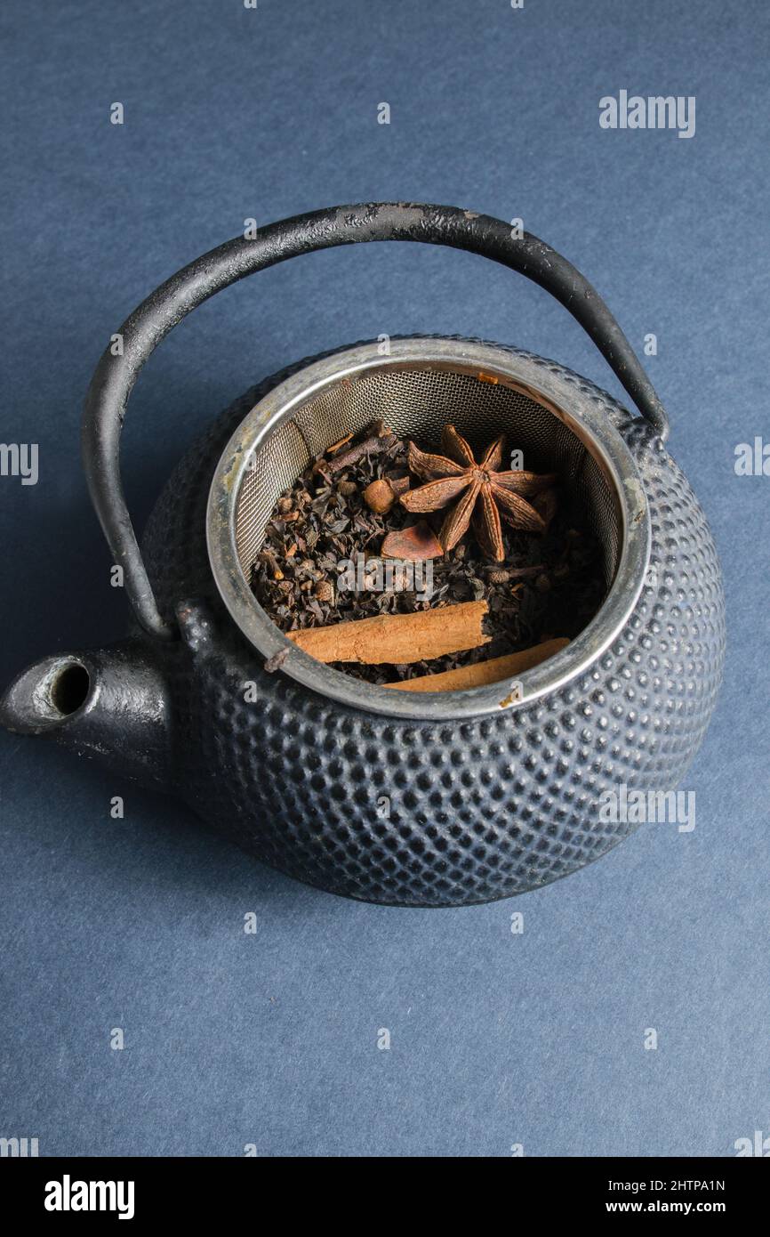 Top view of a teapot with its fresh dried ingredients for a tea on a