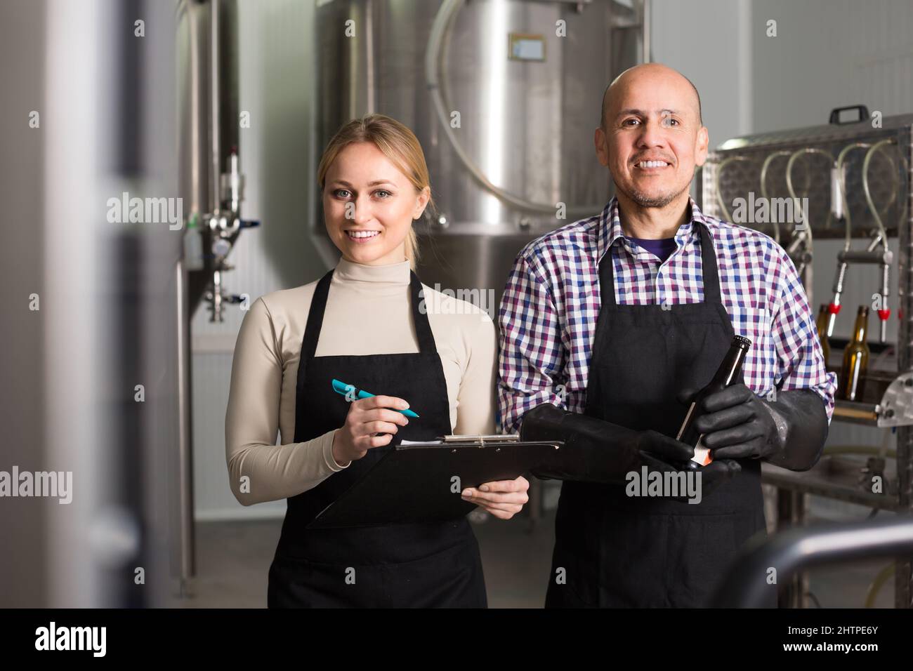 Two brewery workers on beer factory. Stock Photo