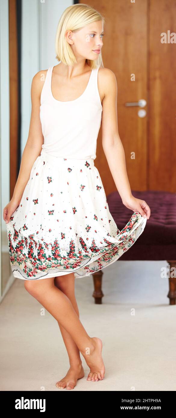 This summer day needs a summer dress. Shot of a young woman wearing a new dress at home. Stock Photo