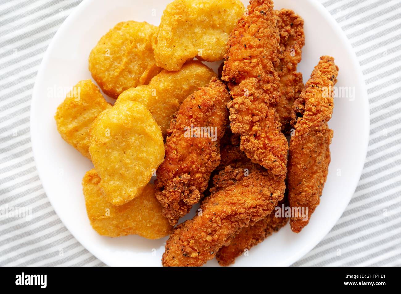 Homemade Nuggets and Chicken Tenders on a Plate, top view. Overhead, from above, flat lay Stock