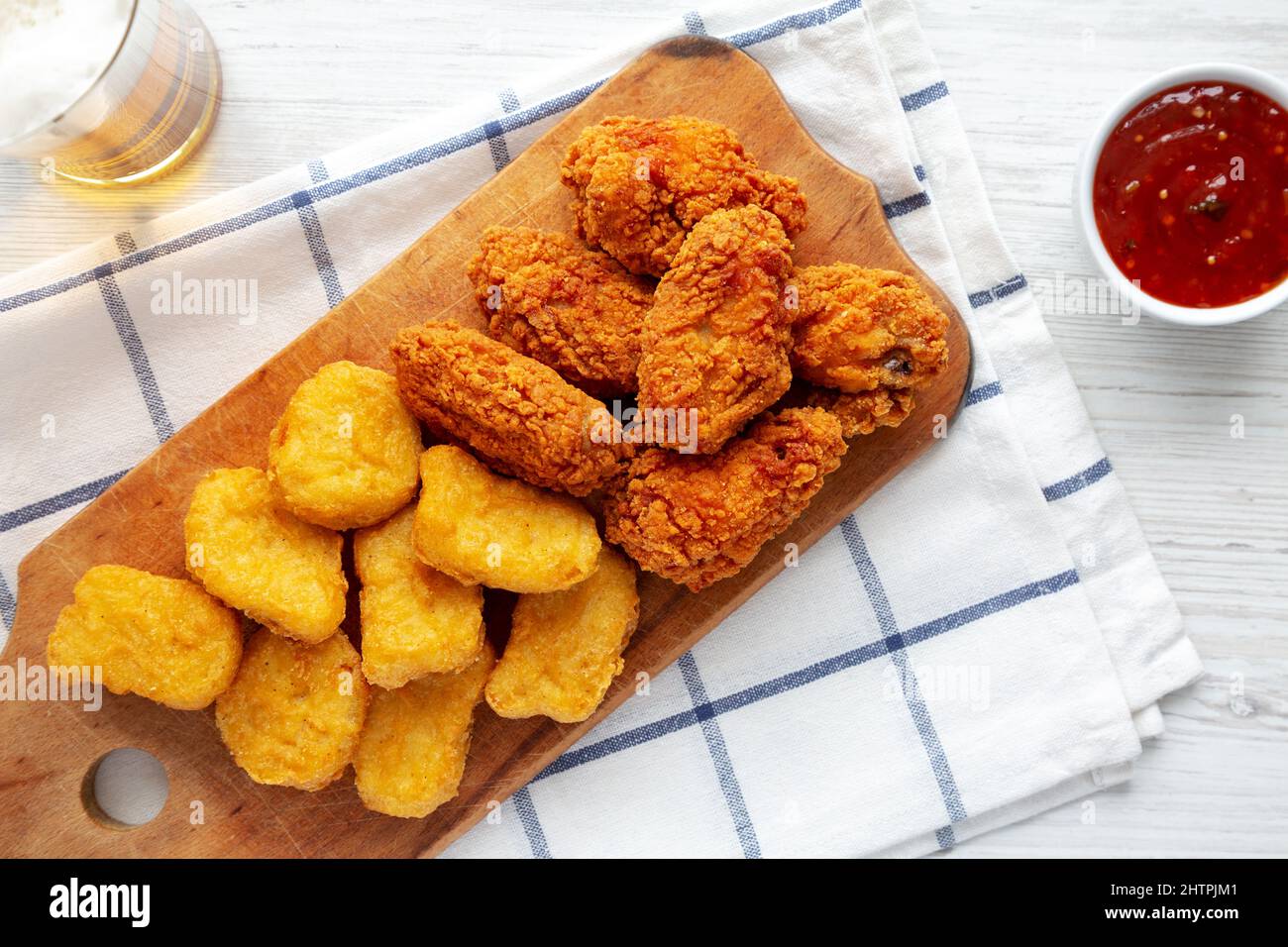 Homemade Crispy Fried Chicken Wings and Nuggets on a rustic wooden board, top view. Flat lay