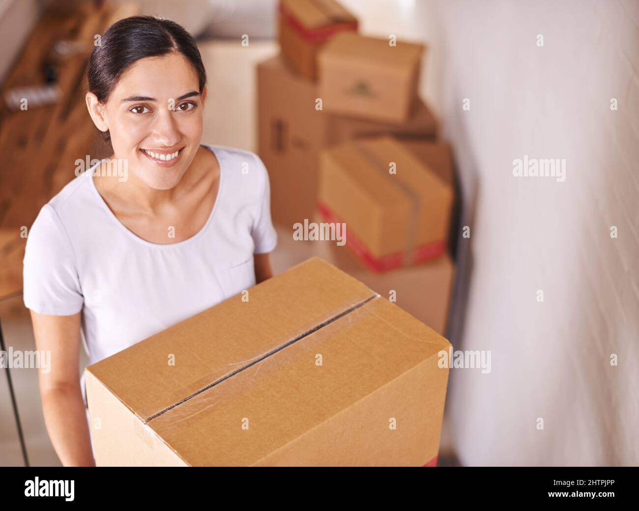 Unpacking her new life. A young woman surrounded by boxes Stock Photo ...
