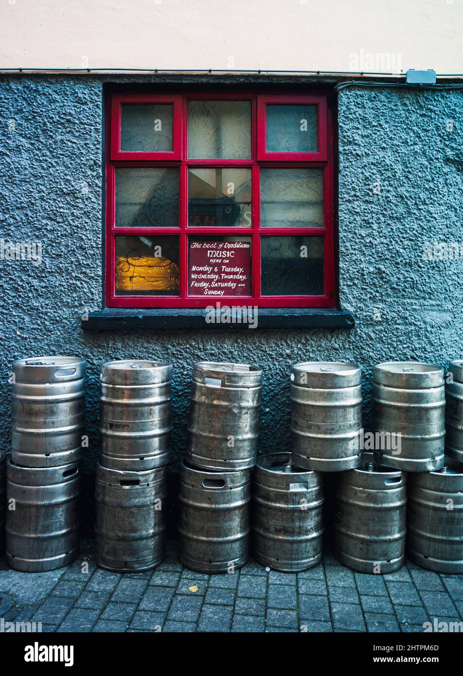 beer kegs outside window of old Irish pub Stock Photo