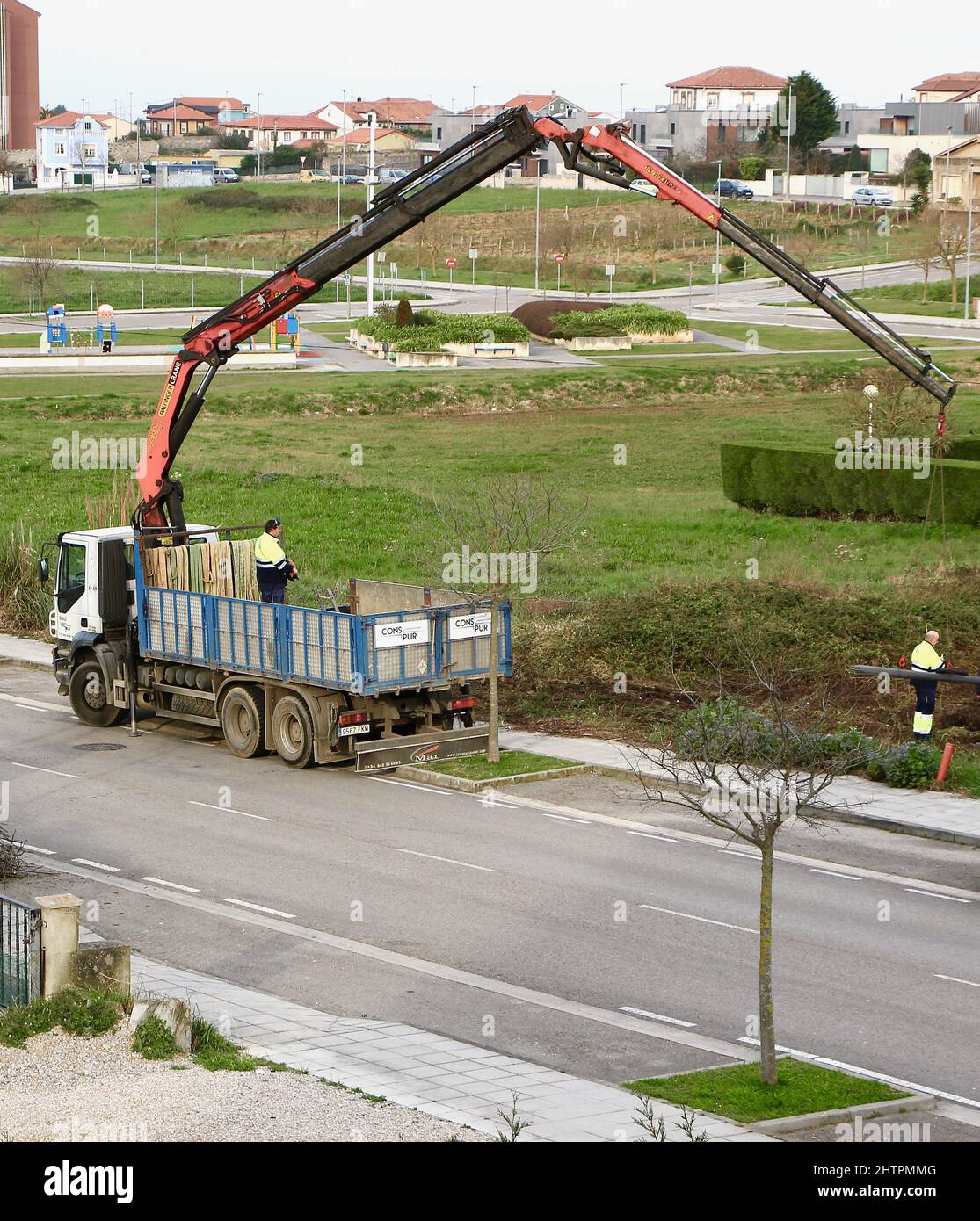 A remote control lorry mounted crane lowering metal rods for fencing