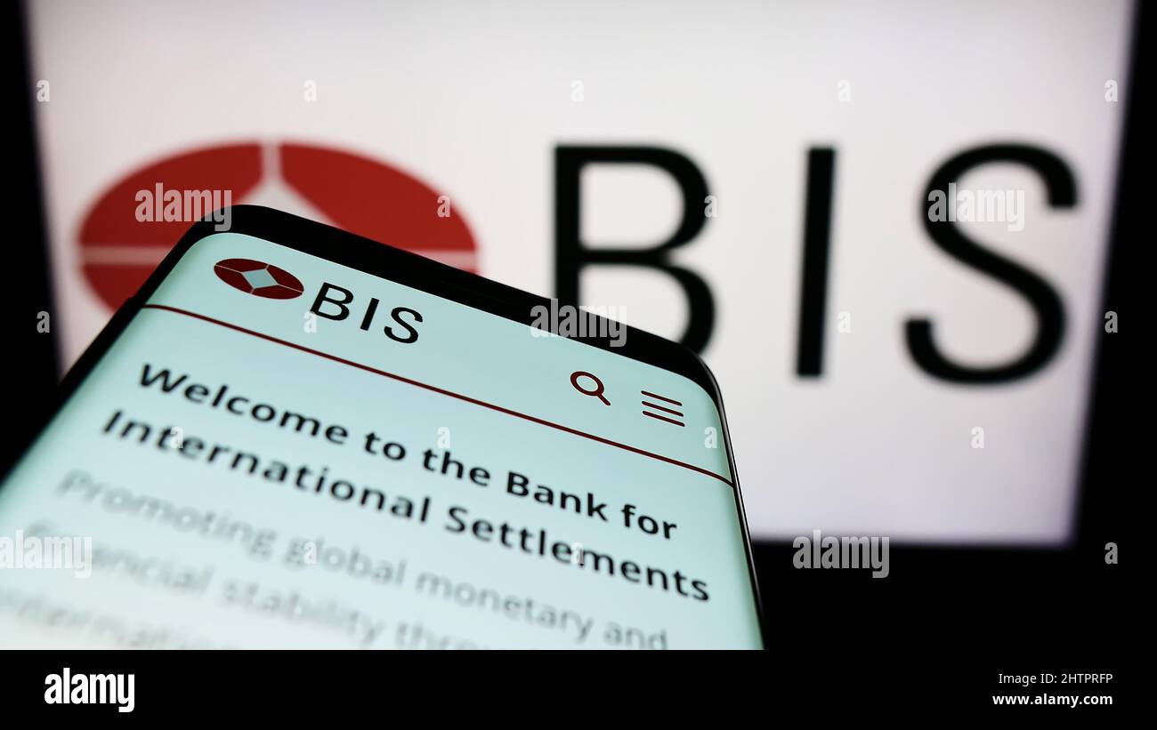 Smartphone with website of Bank for International Settlements (BIS) on screen in front of business logo. Focus on top-left of phone display. Stock Photo
