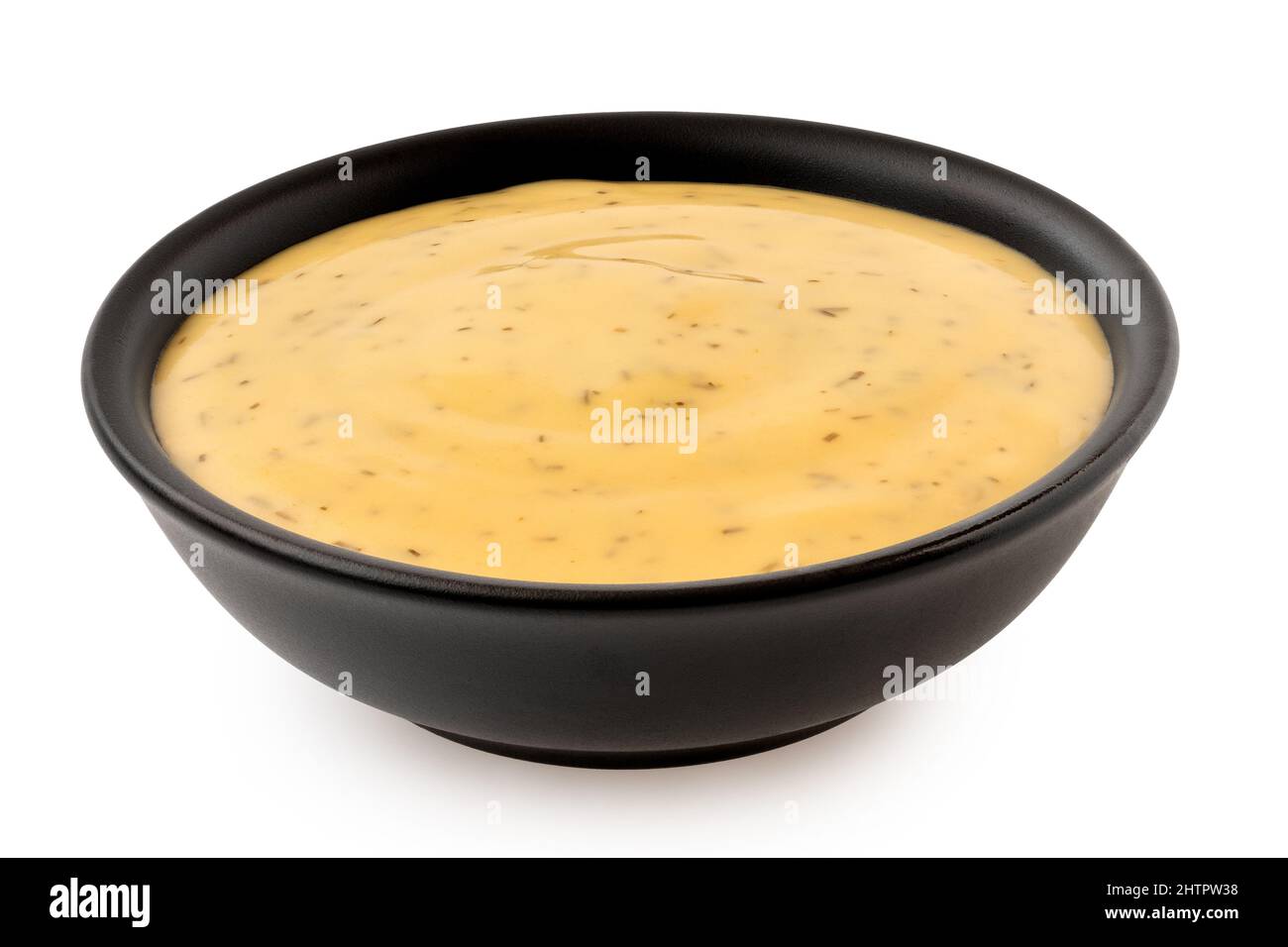 Honey and mustard sauce with dill in a black ceramic bowl isolated on white. Stock Photo