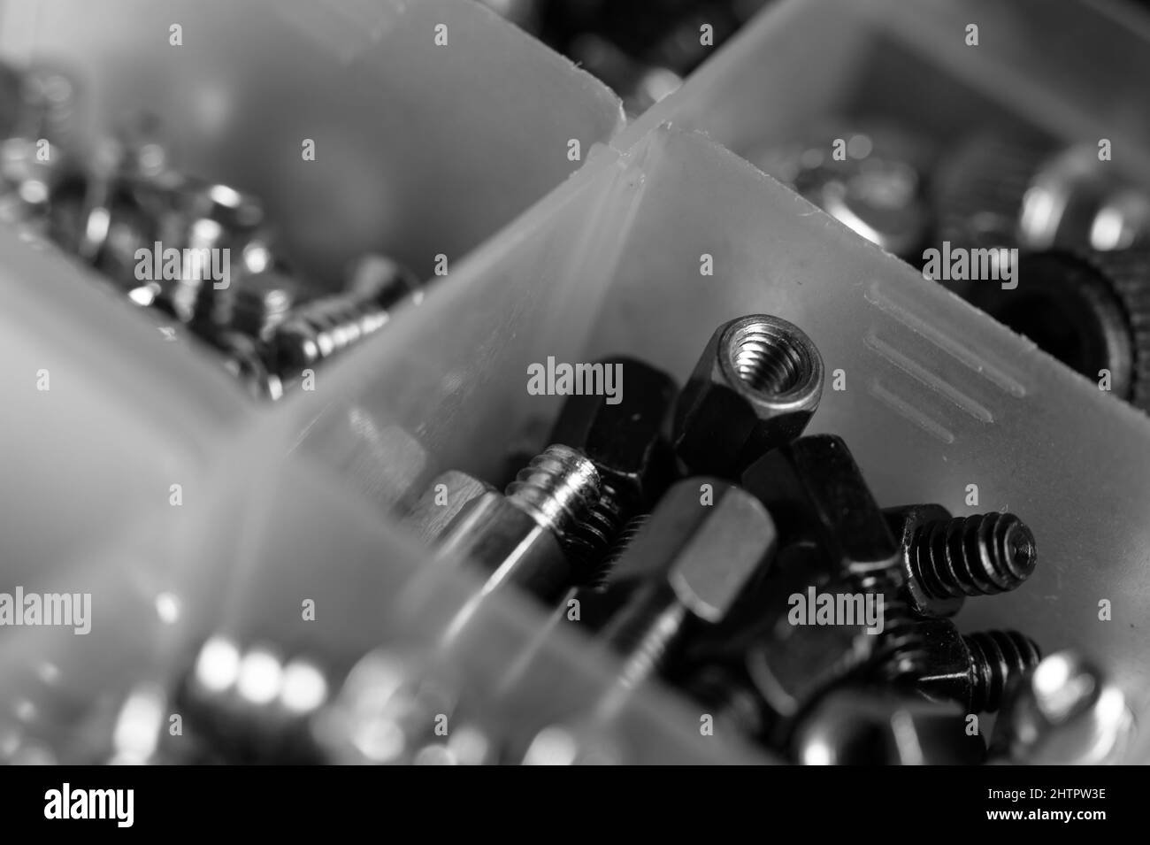 A grayscale shot of screws in boxes Stock Photo